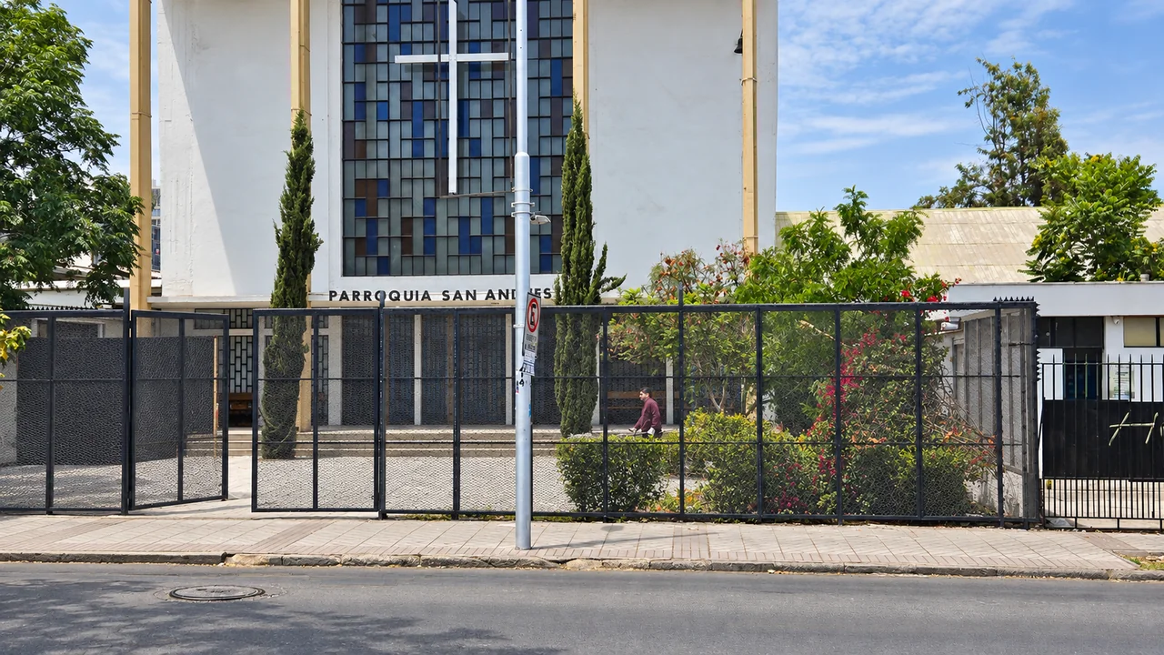 Reja de acceso de la Parroquia San Andrés, con limpieza de auto y escombros en la fotografía