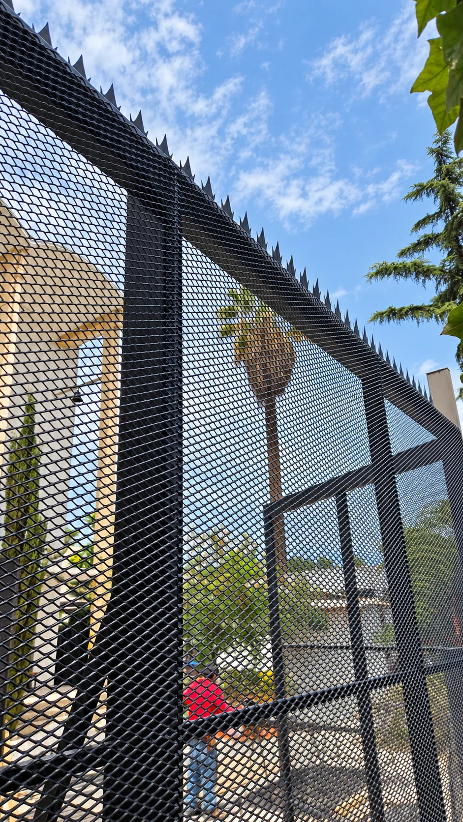 Detalle de la malla metálica desplegada de la reja de acceso de la Parroquia San Andrés