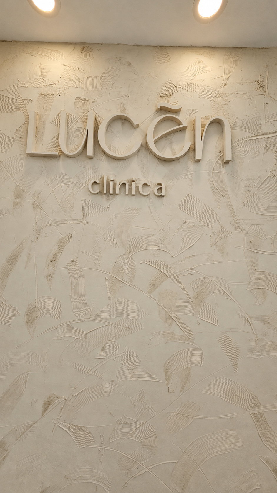 Identidad de Clínica Lucen sobre un muro texturado con iluminación superior